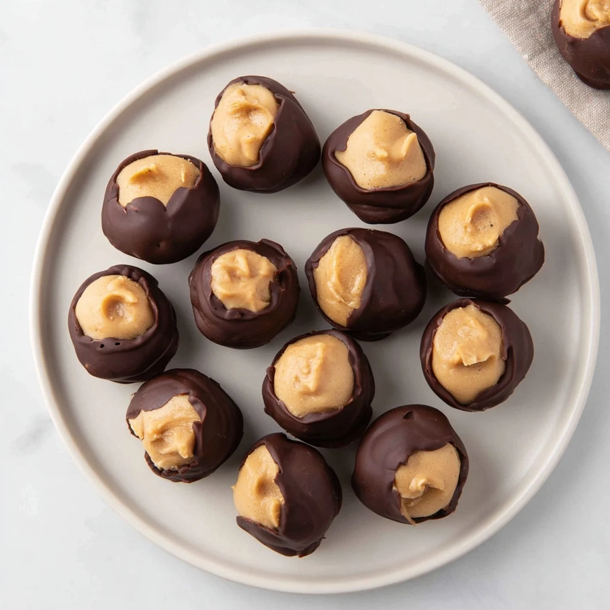 Golden dipped Peanut Butter Buckeyes, a festive treat with creamy peanut butter centers, perfect for sharing.