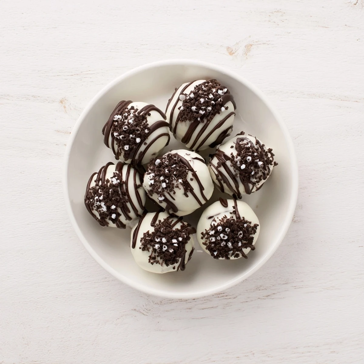 Festive Simplified Christmas Oreo Truffles glistening with a white chocolate coating, ready for serving.