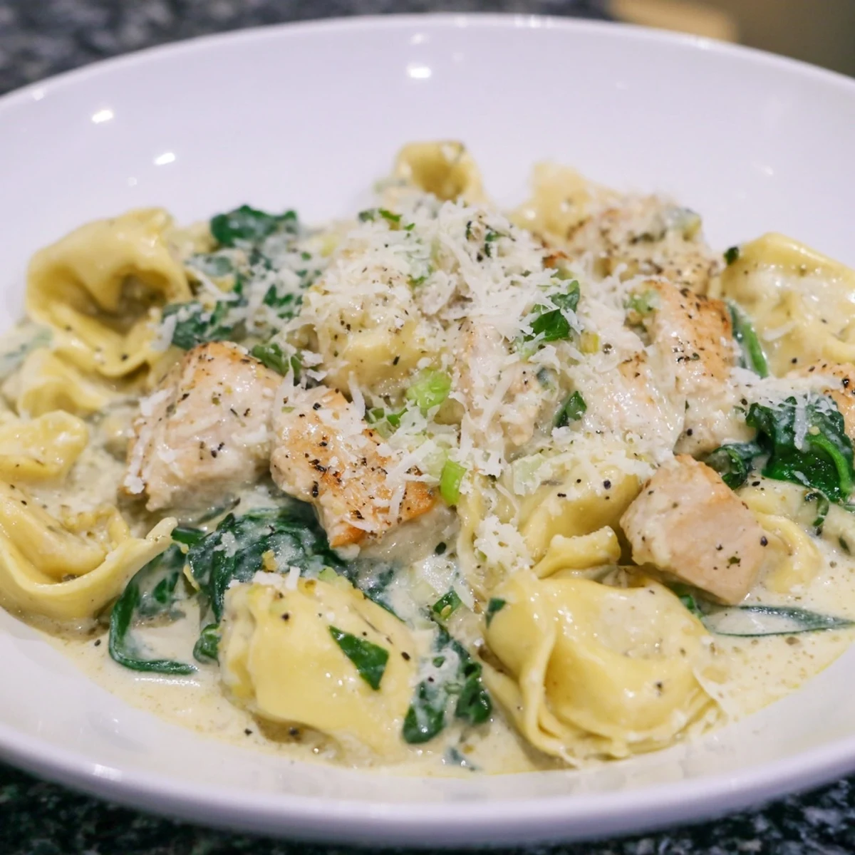 This creamy Chicken and Spinach Tortellini showcases golden chicken pieces and vibrant green spinach in sauce.