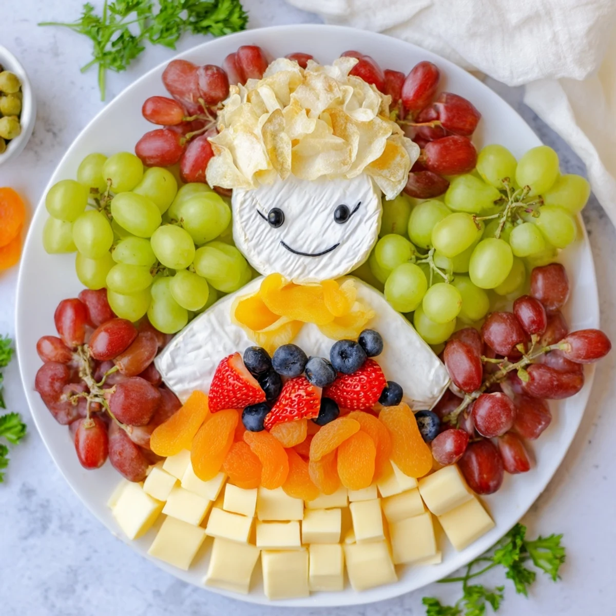 Cherub Angel Snack Tray: a delicious assortment of fruits, cheeses, and treats artfully arranged for a party.
