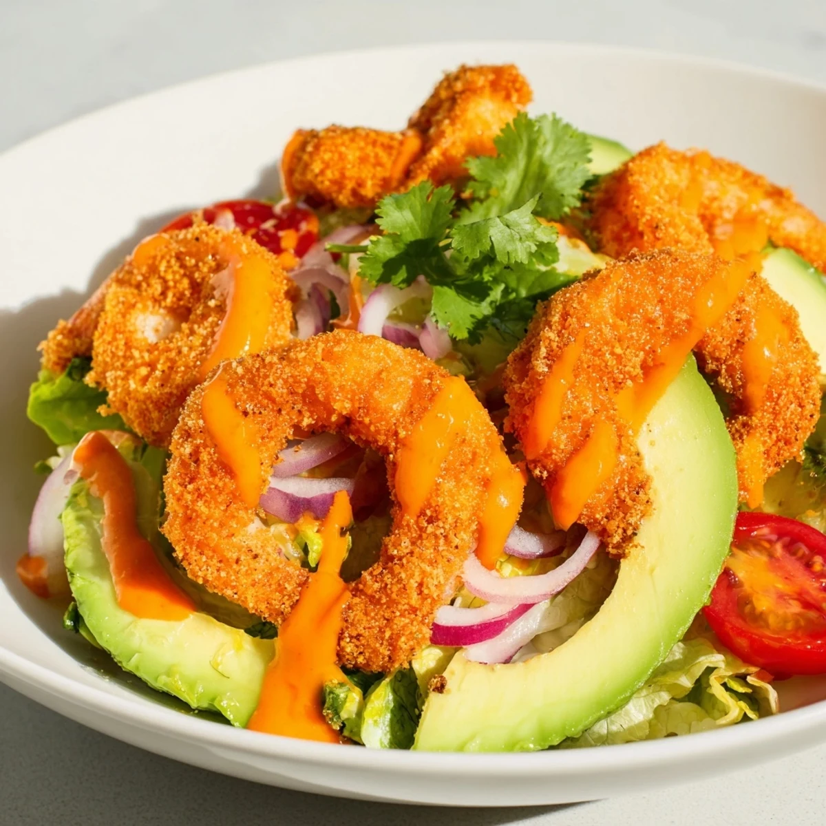 This appetizing Spicy Crispy Shrimp Salad features perfectly fried shrimp with fresh avocado and tomatoes.