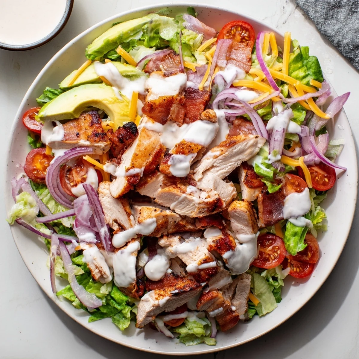 A close-up of Crispy Bacon Chicken Salad, showing cooked chicken, bacon, and creamy ranch.
