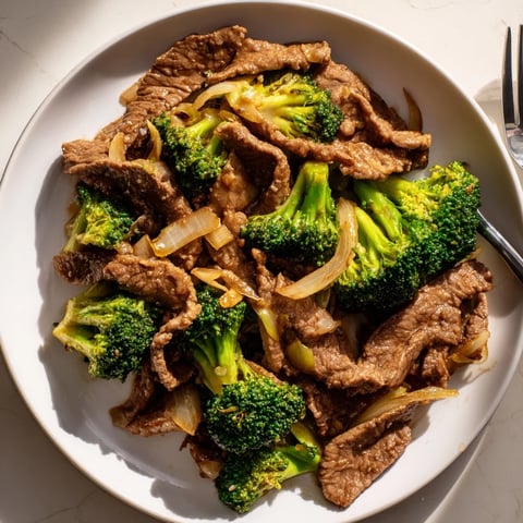 Savory Easy Beef and Broccoli Stir-Fry served over steaming white rice 
