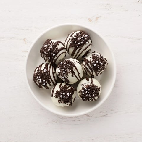 Festive Simplified Christmas Oreo Truffles glistening with a white chocolate coating, ready for serving.
