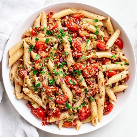 Golden baked tomato & olive oil pasta, glistening with herbs and ready to serve, is an easy vegetarian dinner.
