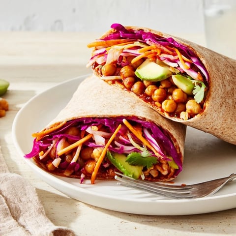 Vibrant BBQ Chickpea & Slaw Wrap with a colorful slaw and creamy avocado slices.