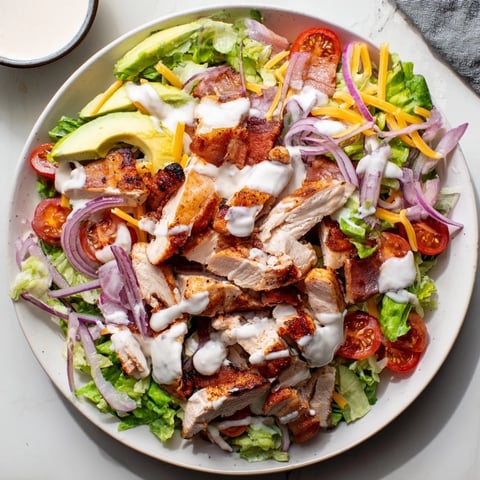 A close-up of Crispy Bacon Chicken Salad, showing cooked chicken, bacon, and creamy ranch.