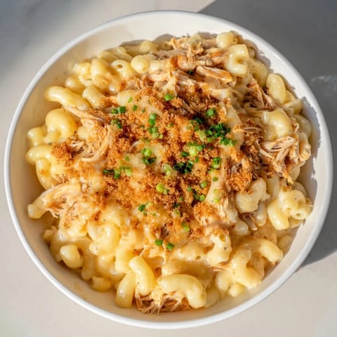 A close-up of cheesy and delicious Classic Mac & Cheese with BBQ Chicken, ready to be served.