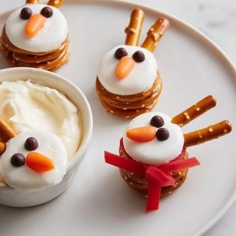 Festive snowman pretzel snacks with creamy dips, inviting for holiday party sharing and delicious flavors.