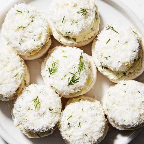 Cream cheese filling peeks through the coconut coating on these Snowball Tea Sandwich Bites.