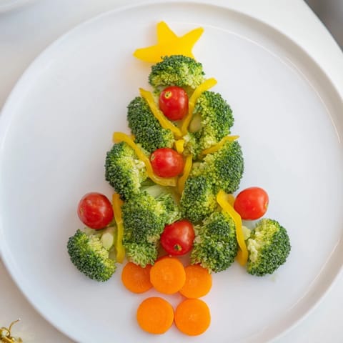 Fresh Broccoli Tree featuring bright red cherry tomatoes for a delicious and visually appealing holiday snack.