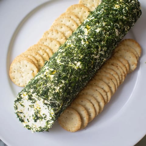 Creamy Herb-Coated Cheese Log, textured with fresh herbs, ready for crackers and entertaining guests.