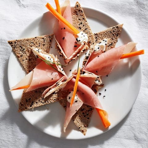 Delicate slices of cured meats folded in an elegant Paper Crane, served with sesame cracker wings.