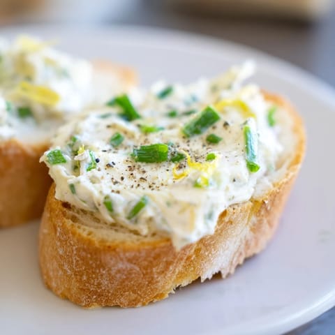 Vodka butter crostini arranged elegantly on a platter, perfect for cocktail parties with a hint of lemon and finely chopped chives.