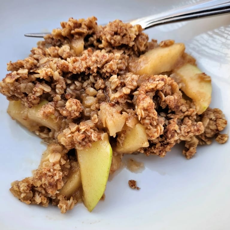 Delicious Best Apple Crisp just out of the oven, with a scoop of melting vanilla ice cream.
