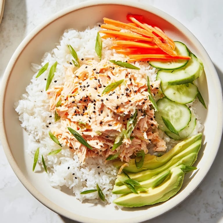 Flaky salmon glistens atop fluffy rice in this quick and easy Spicy Canned Salmon Rice Bowl.