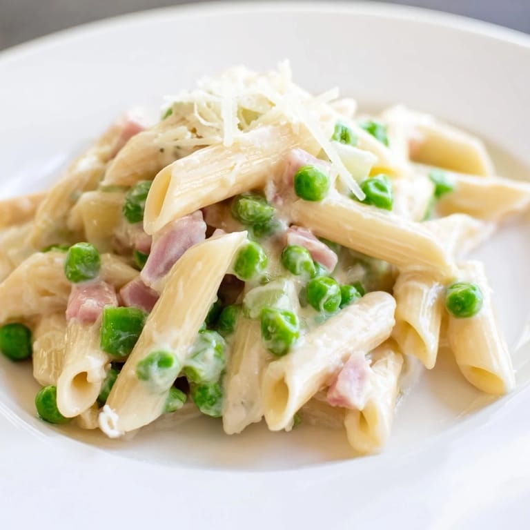 Spring Pea & Ham Pasta tossed with penne, topped with grated Parmesan, served ready for a quick and hearty family dinner.