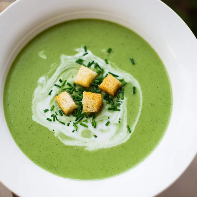 A warm bowl of Creamy Broccoli Soup served with crusty bread, garnished with croutons for a satisfying vegetarian meal.