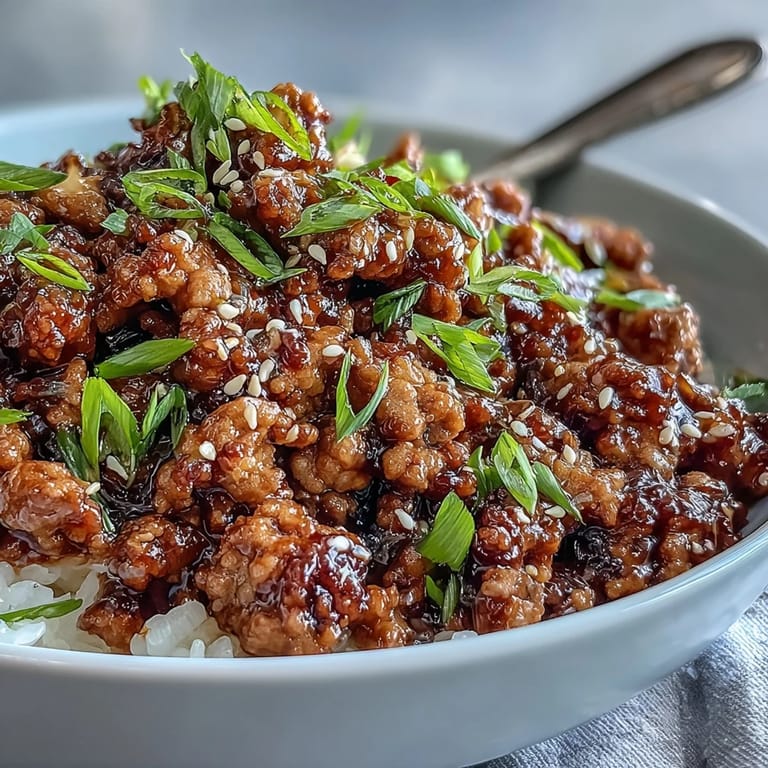 Sizzling Korean-Style Ground Turkey in a hot skillet with chives and sesame seeds, ready to be scooped over rice alongside crisp steamed vegetables.
