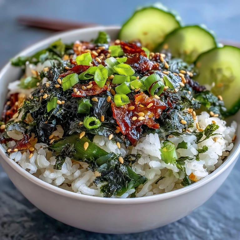 Vibrant sushi rice bowl topped with wakame, nori, scallions, and sesame seeds—perfect for a light vegetarian lunch.