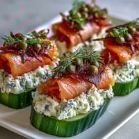 Crisp cucumber rounds topped with creamy dill-infused cheese and savory smoked salmon for a refreshing appetizer.
